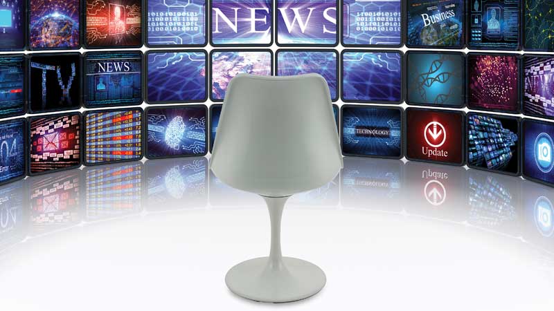 Cadeira vazia virada para muitos ecrãs de televisão 